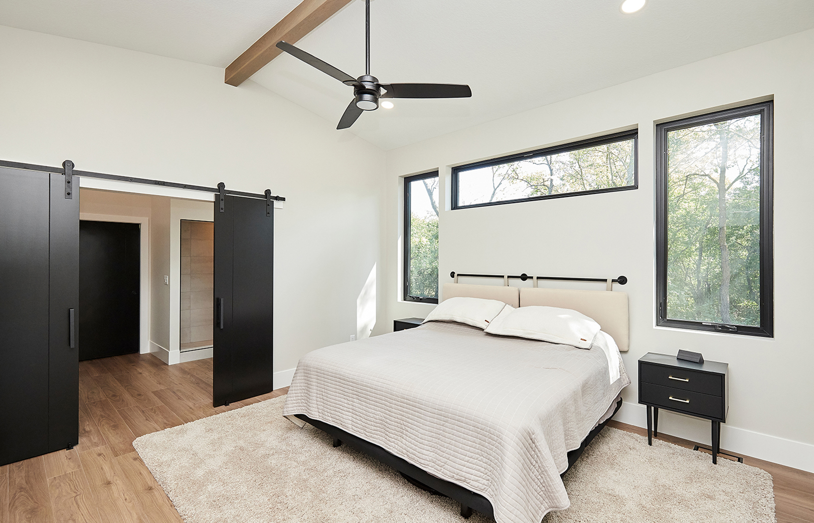 bedroom with custom windows and barndoors to bathroom