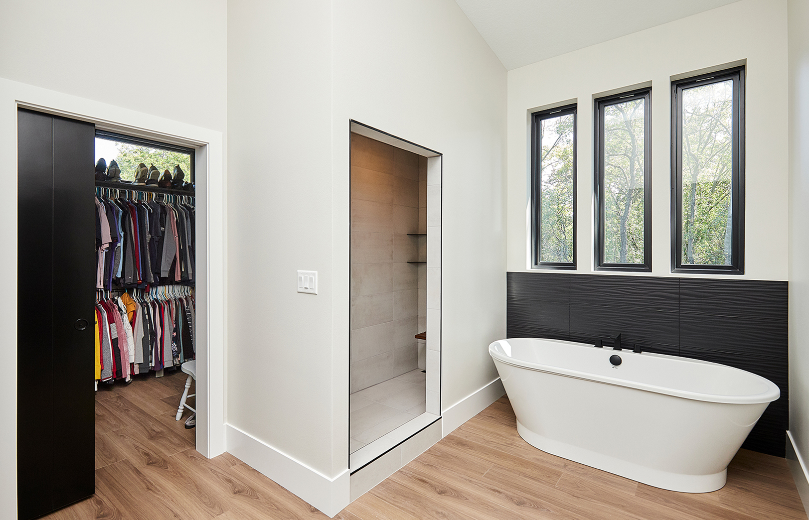 white modern bathtub area looking into walk in closet