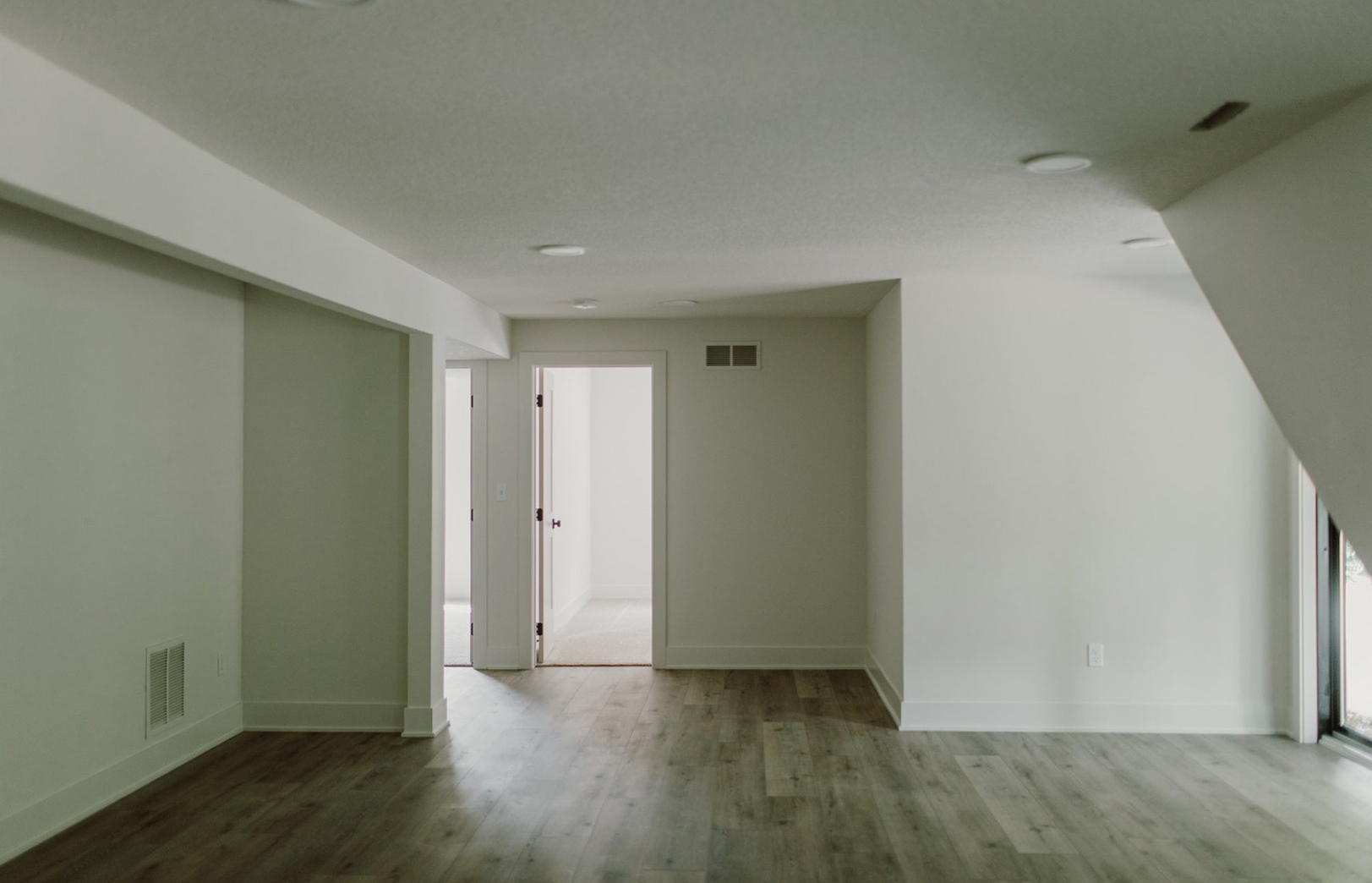 interior room with white walls and grey wood flooring