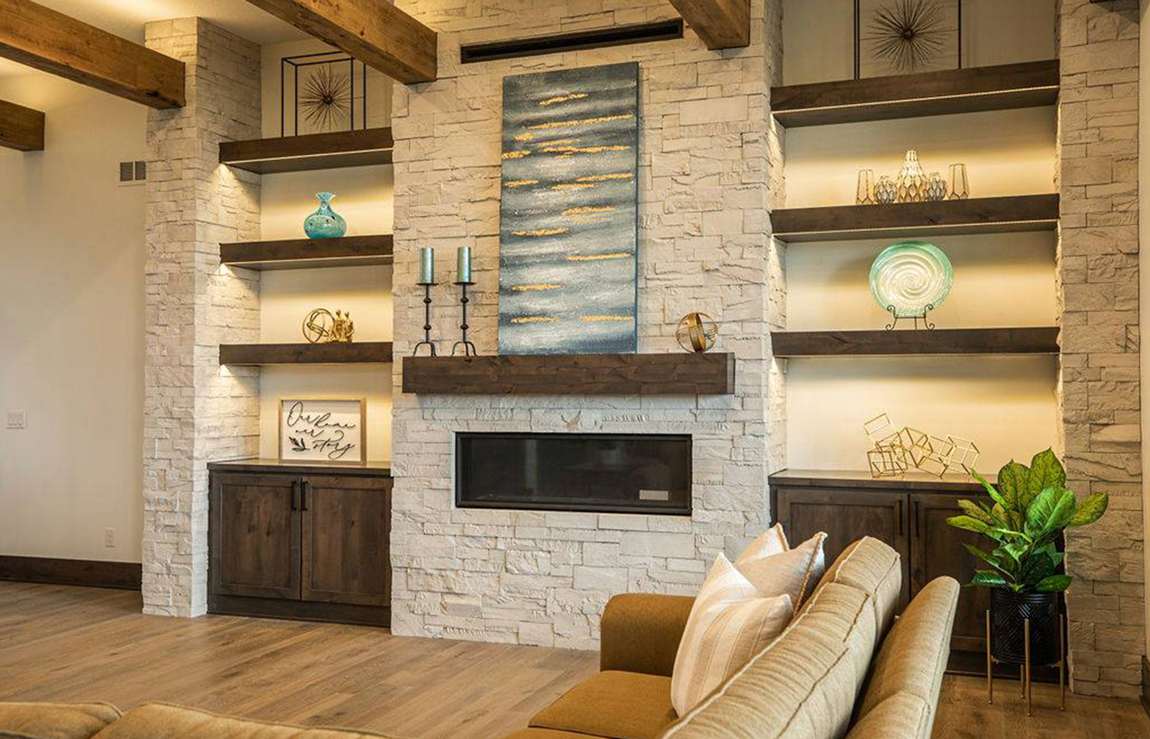 fireplace with large stone walls and wooden shelves on either side