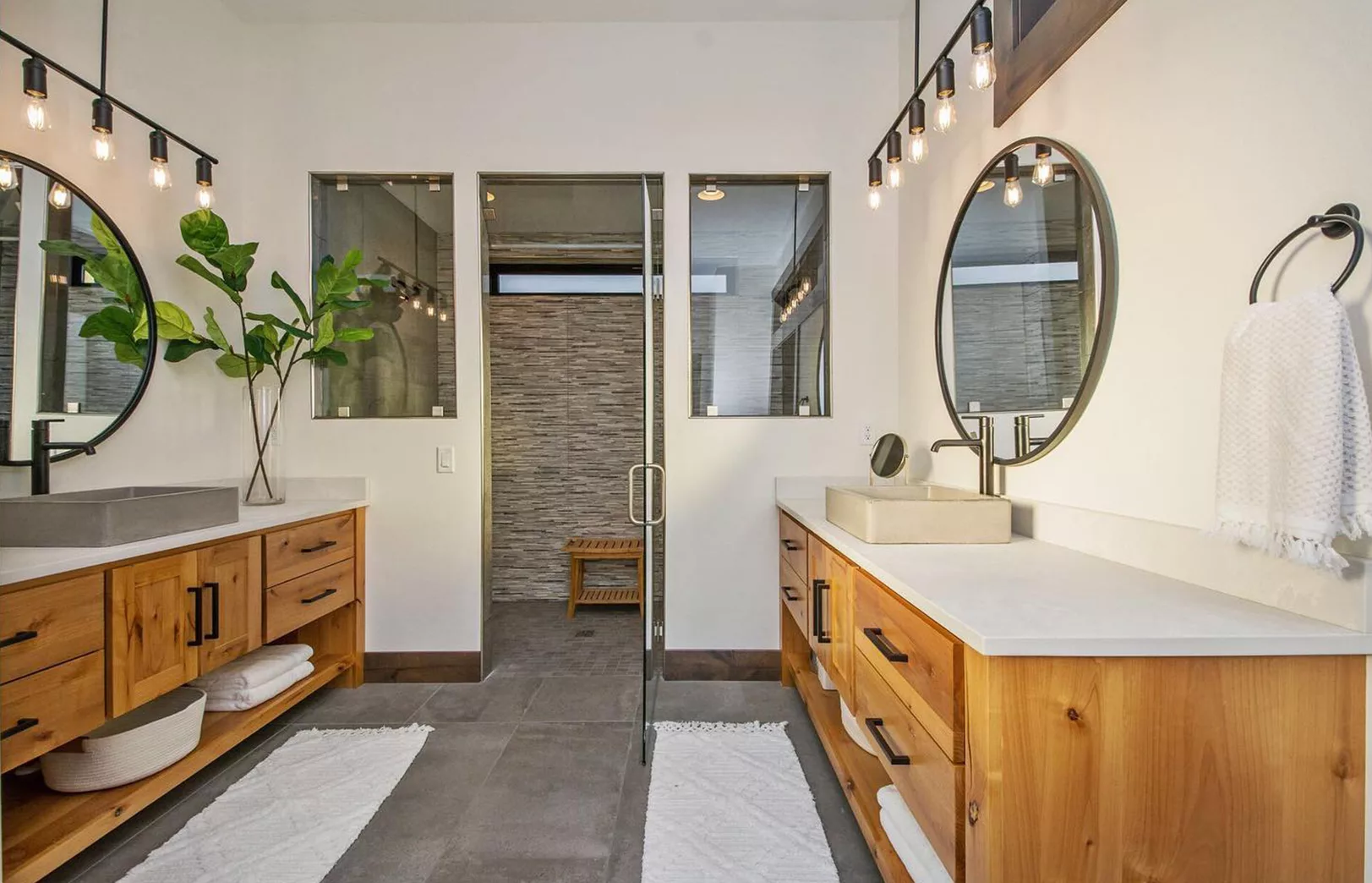 double vanity with concrete sinks looking into large walk-in double shower