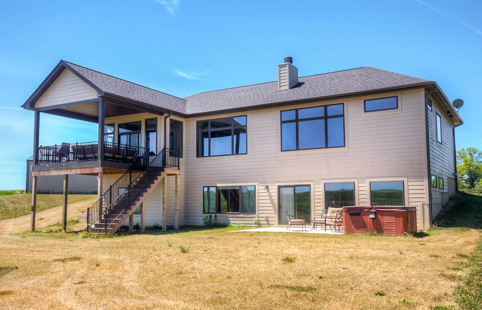 back of house with large windows and covered deck