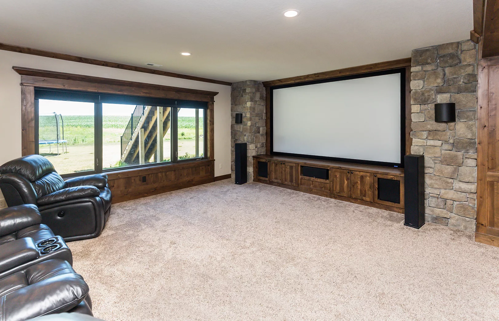 large open movie room with rustic wood and stacked stone surrounding