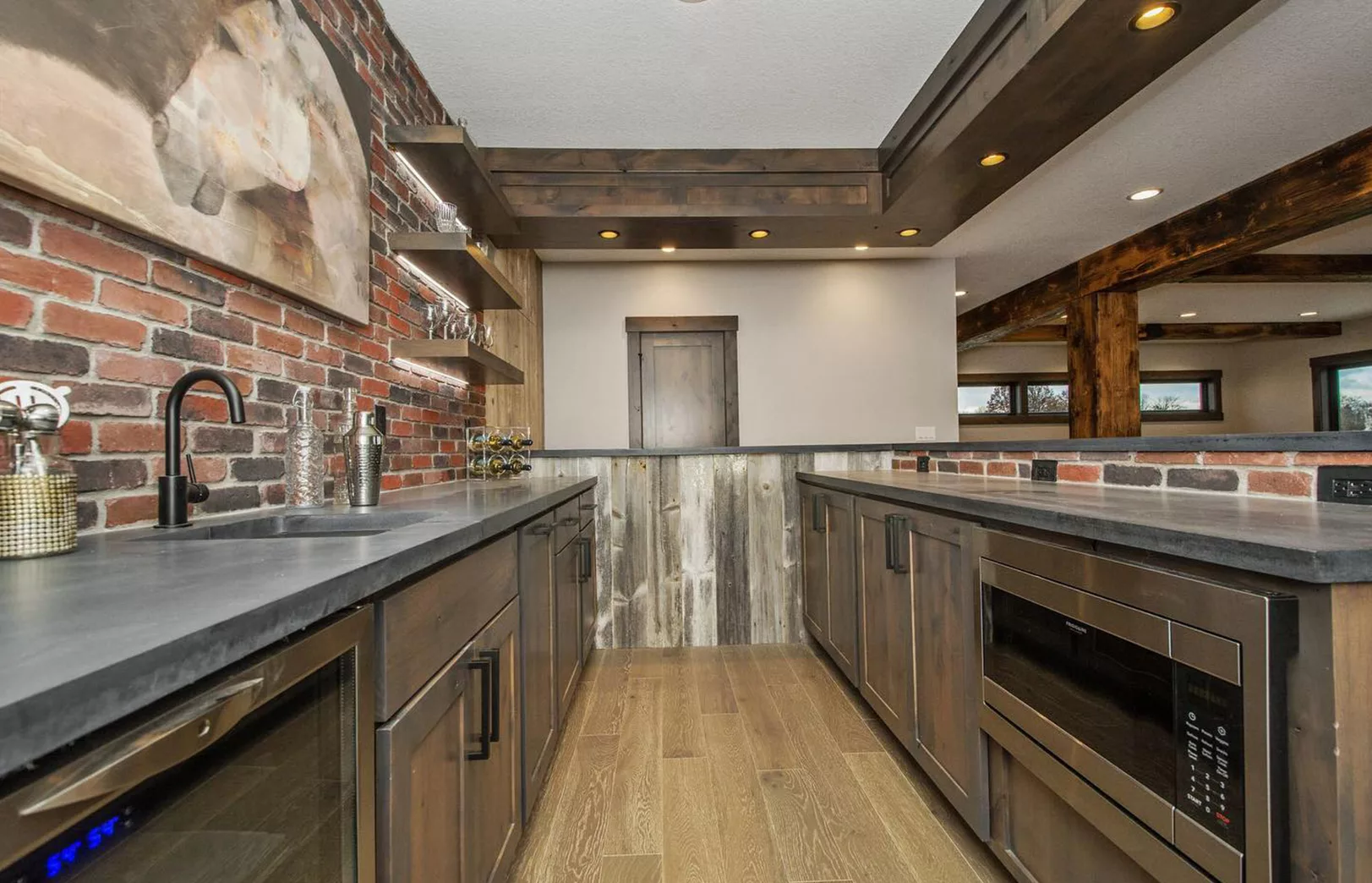 basement bar area with red brick and dark stained wood cabinets
